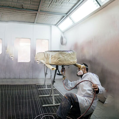 Industrial spray paint booth light fixture protected by TearOff 4-layer peel-away protective film against overspray